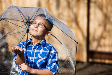 小男孩带着雨伞沐浴在阳光下图片