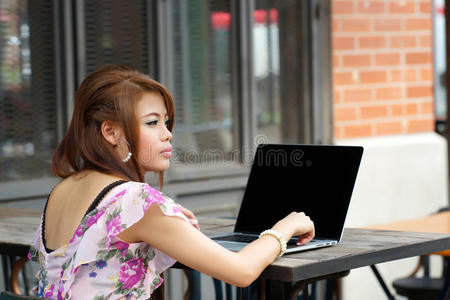年轻迷人的女商人在户外使用笔记本电脑