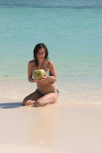 海滩上有椰子的年轻女子