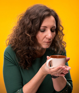 卷曲的女人，端着一杯茶或咖啡