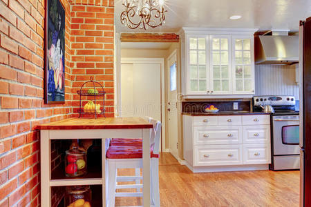 白色厨房，砖墙，硬木和不锈钢炉灶。