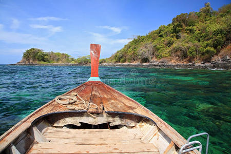 一艘木船在水晶海上驶向科利佩附近美丽的岛屿