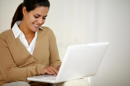 带着微笑的年轻女士在用笔记本电脑