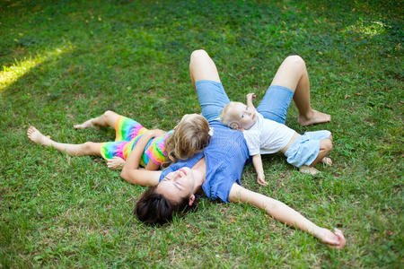 快乐的一家人躺在公园的草地上享受着