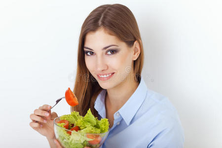 快乐的年轻女子吃着新鲜的沙拉
