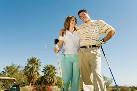 带高尔夫球杆的年轻夫妇