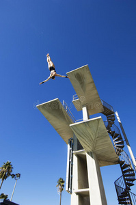 男子游泳运动员在半空中跳水图片