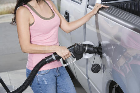 加油奥利给妇女在加油站给汽车加油照片