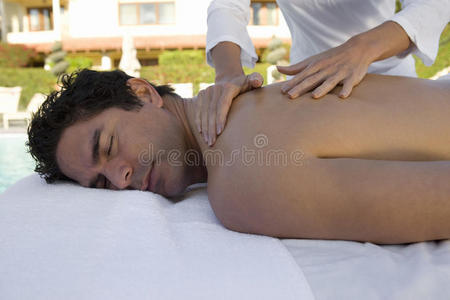 在水疗中心接受背部按摩的男人