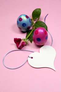 粉色和蓝色圆点复活节彩蛋，白色心形礼品标签垂直玫瑰色。