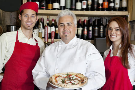 一位快乐的厨师拿着披萨和侍者的画像