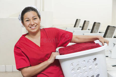 一位快乐的年轻女员工提着洗衣篮的画像