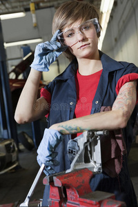 车库里一位戴护目镜的年轻女机修工的画像