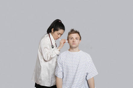 医生用手电筒检查病人的耳朵