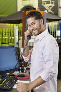 一位快乐的售货员在店里听电话的画像