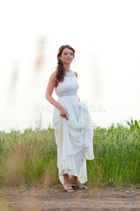 站在田野里的一个穿着白衣服的微笑的女人