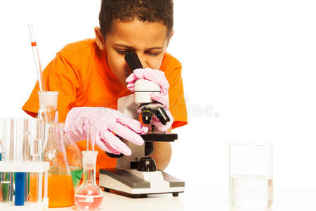 可爱的黑人男孩看着显微镜