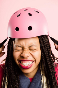 滑稽女子戴自行车头盔肖像粉色背景真实