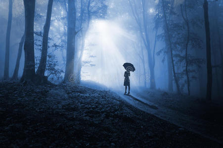黑暗中面对光明的女人照片