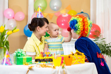 女婴与父母和小丑庆祝一岁生日