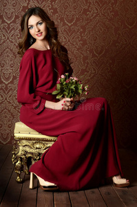 穿着深红色连衣裙的优雅性感的年轻女子