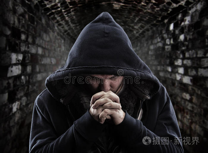 黑袍人站在黑暗中忍者铁链者十字架前的和尚祈祷的强盗愤怒的道德困境