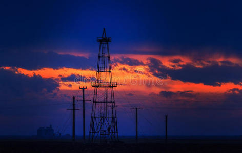 夕阳天空下的石油钻井平台油田图片
