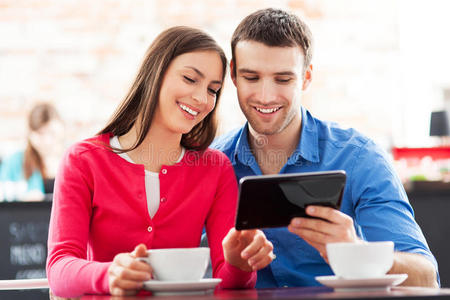 情侣在咖啡馆使用数码平板电脑