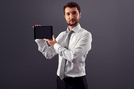 穿着正式服装的严肃男士，带平板电脑