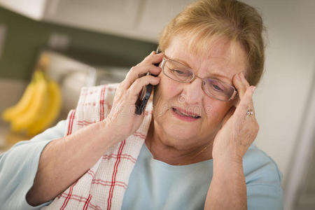 厨房里用手机打惊吓的老年妇女