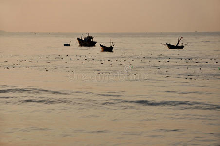 日出时海上渔船，梅内，越南