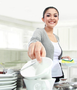 微笑的女人开心地洗盘子