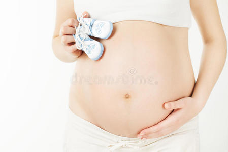 怀孕的肚子和新生的婴儿靴