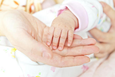 抱着母亲的手的婴儿手特写镜头