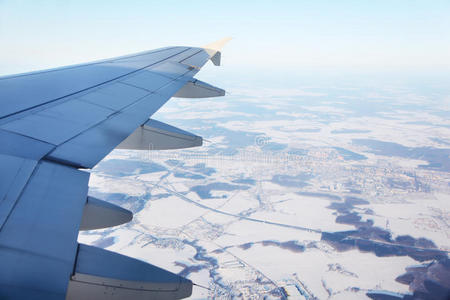 飞机机翼和冰雪覆盖的小镇俯瞰图照片