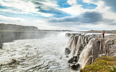 站在冰岛东北部瓦特纳约克尔国家公园著名的塞尔沃斯瀑布附近的妇女