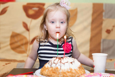 女孩在生日蛋糕上吹蜡烛
