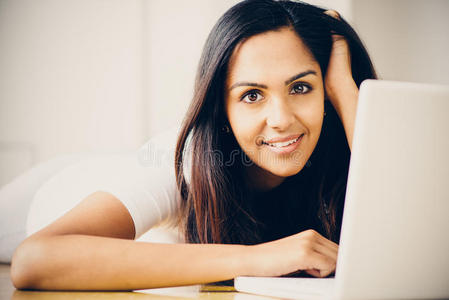 漂亮的印度女学生在家使用笔记本电脑