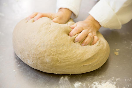 面包师在面包房揉搓新鲜面团