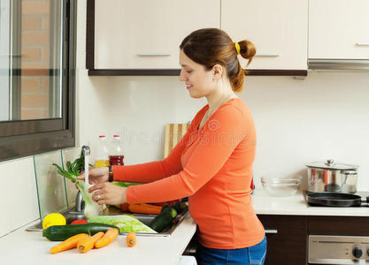 妇女在厨房洗蔬菜