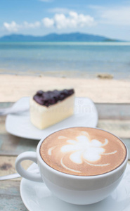咖啡杯和蛋糕在露台面对海景图片