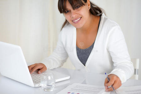 在办公室用笔记本电脑工作的年轻女子