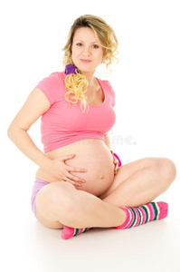 幸福的孕妇抱着肚子坐着