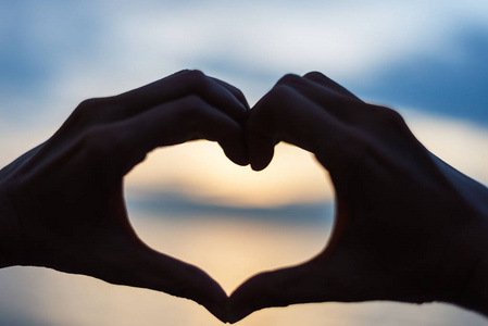 用照片摆心做心的形状,用双手在湖岸上的夫妇.人剪影老式照片照片