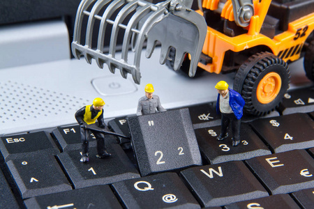 小小的玩具团队的工程师在维修键盘电脑笔记本。C