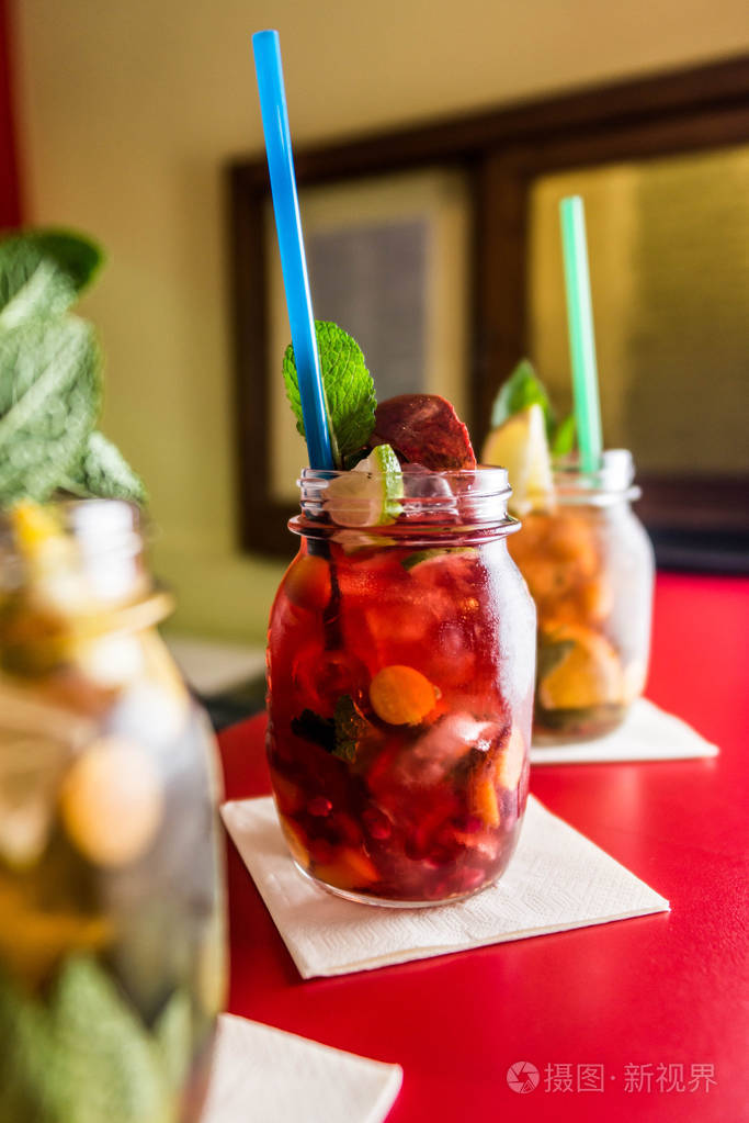 自制柠檬水冰茶五颜六色的icetea饮料与新鲜的甜水果薄荷叶在玻璃上的