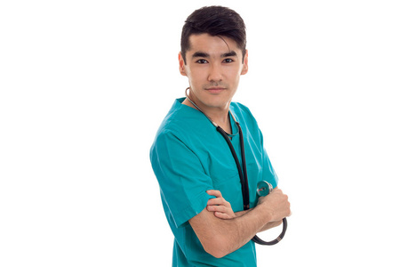 美丽年轻的男医生用听诊器在统一构成孤立在白色背景上