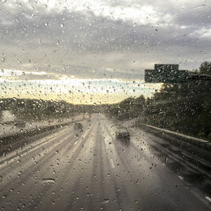 车窗上的雨滴在公路上开着模糊的路