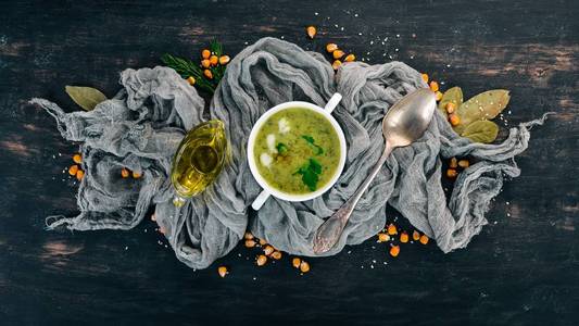 一碗椰菜豌豆和蔬菜汤。健康食品。在黑色的木质背景。顶部视图。复制文本的空间