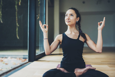 华丽的年轻女子，练瑜伽室内的视图。美丽的女孩实践半鱼在类中。平静和放松，女性幸福感概念。横向的 模糊的背景